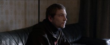 Movie still from “Dheepan” (2015), directed by Jacques Audiard – A person sitting on a couch; Close Up shot, Over the shoulder angle