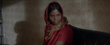 Movie still from “Dheepan” (2015), directed by Jacques Audiard – A woman in a red dress with a scarf around her neck; Close Up shot, Low angle