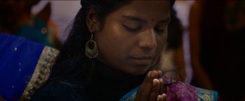 Movie still from “Dheepan” (2015), directed by Jacques Audiard – A woman with her eyes closed and her hands clasped in prayer; Close Up shot, Low angle