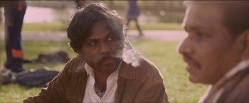 Movie still from “Dheepan” (2015), directed by Jacques Audiard – A person smoking a cigarette; Close Up shot, Over the shoulder angle