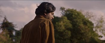 Movie still from “Dheepan” (2015), directed by Jacques Audiard – A person wearing a brown jacket; Close Up shot, Low angle