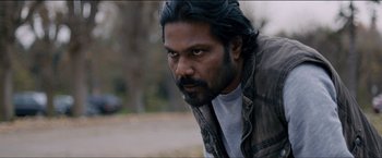 Movie still from “Dheepan” (2015), directed by Jacques Audiard – A person with long black hair; Close Up shot, Low angle