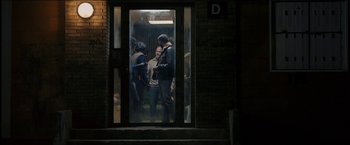 Movie still from “Dheepan” (2015), directed by Jacques Audiard – A group of people standing outside of a building; Wide shot, Over the shoulder angle