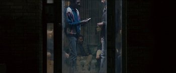 Movie still from “Dheepan” (2015), directed by Jacques Audiard – A group of people sitting on a bench; Wide shot, High angle