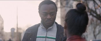 Movie still from “Dheepan” (2015), directed by Jacques Audiard – A man in a black jacket talking to a woman; Close Up shot, Over the shoulder angle