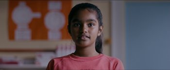 Movie still from “Dheepan” (2015), directed by Jacques Audiard – A young girl is posing for a picture; Close Up shot, Low angle