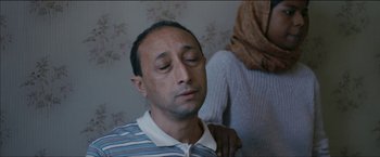 Movie still from “Dheepan” (2015), directed by Jacques Audiard – A man with his eyes closed and his hand on his shoulder; Close Up shot, Over the shoulder angle