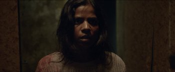 Movie still from “Dheepan” (2015), directed by Jacques Audiard – A person with long hair is looking at the camera; Close Up shot, Over the shoulder angle