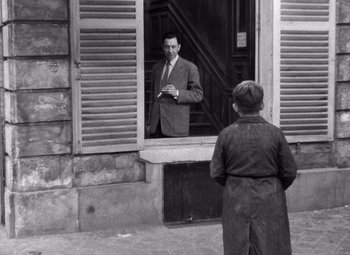 Movie still from “Diabolique” (1955), directed by Henri-Georges Clouzot – An old photo of a man looking in a mirror; Wide shot, Over the shoulder angle