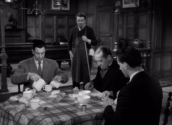 Movie still from “Diabolique” (1955), directed by Henri-Georges Clouzot – A group of men sitting at a table with food; Medium shot, High angle