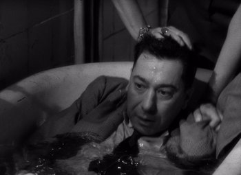 Movie still from “Diabolique” (1955), directed by Henri-Georges Clouzot – A black and white photo of a man in a tub; Close Up shot, High angle