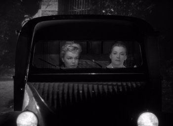 Movie still from “Diabolique” (1955), directed by Henri-Georges Clouzot – Two women in the back of an old car; Medium shot, Low angle