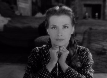 Movie still from “Diabolique” (1955), directed by Henri-Georges Clouzot – A black - and - white photo of a woman with her hands under her chin; Close Up shot, High angle