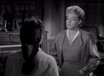 Movie still from “Diabolique” (1955), directed by Henri-Georges Clouzot – A woman standing next to another woman in front of a fireplace; Close Up shot, Over the shoulder angle