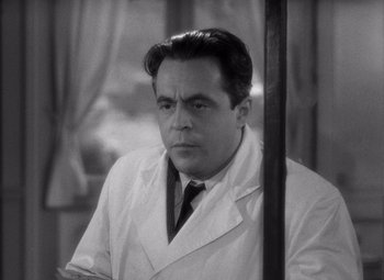 Movie still from “Diabolique” (1955), directed by Henri-Georges Clouzot – Black and white photograph of a man wearing a lab coat; Close Up shot, Low angle