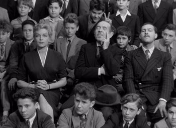 Movie still from “Diabolique” (1955), directed by Henri-Georges Clouzot – A black and white photo of a group of young men and women; Medium shot, High angle