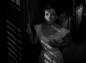 Movie still from “Diabolique” (1955), directed by Henri-Georges Clouzot – A black and white photo of a woman in a white dress; Medium shot, High angle