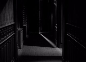 Movie still from “Diabolique” (1955), directed by Henri-Georges Clouzot – A dark room with a door open and sunlight coming through the window; Extreme Wide shot, High angle