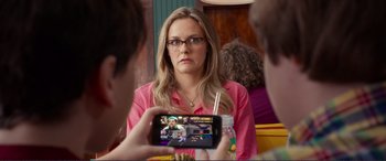 Movie still from “Diary of a Wimpy Kid: The Long Haul” (2017), directed by David Bowers – A woman in a pink shirt is taking a picture of herself; Close Up shot, Over the shoulder angle