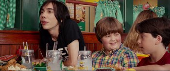 Movie still from “Diary of a Wimpy Kid: The Long Haul” (2017), directed by David Bowers – Two people sitting at a table with food on it; Medium shot, Over the shoulder angle