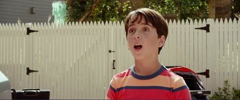 Movie still from “Diary of a Wimpy Kid: The Long Haul” (2017), directed by David Bowers – A young boy standing in front of a white picket fence; Close Up shot, Low angle