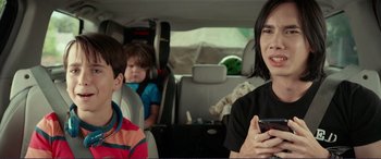Movie still from “Diary of a Wimpy Kid: The Long Haul” (2017), directed by David Bowers – A woman and two children in the back seat of a car; Medium shot, Over the shoulder angle