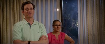 Movie still from “Diary of a Wimpy Kid: The Long Haul” (2017), directed by David Bowers – A man and a woman sitting next to each other in front of a window; Medium shot, Low angle