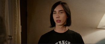 Movie still from “Diary of a Wimpy Kid: The Long Haul” (2017), directed by David Bowers – A man with long black hair wearing a t - shirt; Close Up shot, Over the shoulder angle