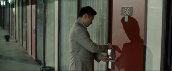 Movie still from “Diary of a Wimpy Kid: The Long Haul” (2017), directed by David Bowers – A man in a business suit is putting a key into a door; Medium shot, Over the shoulder angle