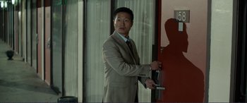 Movie still from “Diary of a Wimpy Kid: The Long Haul” (2017), directed by David Bowers – A man in a suit and tie opening a door; Medium shot, Over the shoulder angle