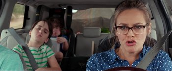 Movie still from “Diary of a Wimpy Kid: The Long Haul” (2017), directed by David Bowers – A woman sitting in the back of a car with two children in the back seat; Close Up shot, Over the shoulder angle