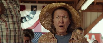 Movie still from “Diary of a Wimpy Kid: The Long Haul” (2017), directed by David Bowers – An older woman wearing a straw hat and a floral shirt; Close Up shot, Over the shoulder angle