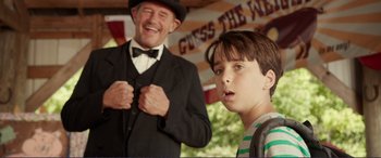 Movie still from “Diary of a Wimpy Kid: The Long Haul” (2017), directed by David Bowers – A man and a young boy in front of an american flag; Medium shot, Over the shoulder angle