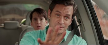 Movie still from “Diary of a Wimpy Kid: The Long Haul” (2017), directed by David Bowers – A young man and older man sitting in a car; Close Up shot, Over the shoulder angle