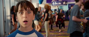 Movie still from “Diary of a Wimpy Kid: The Long Haul” (2017), directed by David Bowers – A young boy is looking surprised at a crowd; Close Up shot, Over the shoulder angle