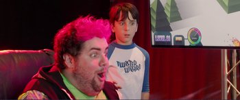 Movie still from “Diary of a Wimpy Kid: The Long Haul” (2017), directed by David Bowers – A man with pink hair standing next to a young boy; Medium shot, Over the shoulder angle
