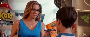 Movie still from “Diary of a Wimpy Kid: The Long Haul” (2017), directed by David Bowers – A woman holding a cell phone in front of a mirror; Close Up shot, Over the shoulder angle