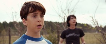 Movie still from “Diary of a Wimpy Kid: The Long Haul” (2017), directed by David Bowers – Two young boys standing next to each other in a wooded area; Close Up shot, Over the shoulder angle