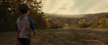 Movie still from “Diary of a Wimpy Kid: The Long Haul” (2017), directed by David Bowers – A person standing on top of a grass covered field; Extreme Wide shot, High angle