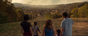 Movie still from “Diary of a Wimpy Kid: The Long Haul” (2017), directed by David Bowers – A group of people standing on top of a grass covered field; Wide shot, High angle