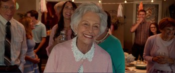 Movie still from “Diary of a Wimpy Kid: The Long Haul” (2017), directed by David Bowers – An older woman smiling for the camera while two other women look on; Close Up shot, Over the shoulder angle