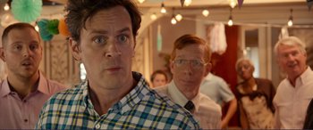 Movie still from “Diary of a Wimpy Kid: The Long Haul” (2017), directed by David Bowers – A man in a plaid shirt standing next to another man in glasses; Close Up shot, Over the shoulder angle