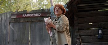 Movie still from “Diary of a Wimpy Kid: The Long Haul” (2017), directed by David Bowers – A woman holding a small pig in her hands; Medium shot, Over the shoulder angle