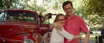 Movie still from “Diary of a Wimpy Kid: The Long Haul” (2017), directed by David Bowers – A man and a woman standing in front of an old fire truck; Medium shot, Over the shoulder angle