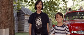 Movie still from “Diary of a Wimpy Kid: The Long Haul” (2017), directed by David Bowers – Two young men standing next to each other in front of a building; Medium shot, Over the shoulder angle