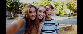Movie still from “Diary of a Wimpy Kid: The Long Haul” (2017), directed by David Bowers – A group of three young people posing for a picture; Close Up shot, High angle