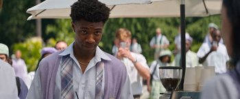 Movie still from “Do Revenge” (2022), directed by Jennifer Kaytin Robinson – A man in a purple shirt and a purple tie; Close Up shot, Over the shoulder angle