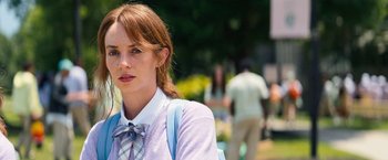 Movie still from “Do Revenge” (2022), directed by Jennifer Kaytin Robinson – A woman in a purple shirt and a bow tie; Close Up shot, Over the shoulder angle