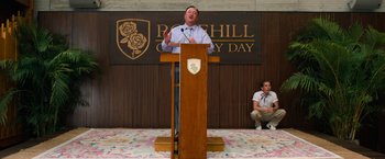 Movie still from “Do Revenge” (2022), directed by Jennifer Kaytin Robinson – A man standing at a podium speaking to a crowd of onlookers; Wide shot, Low angle