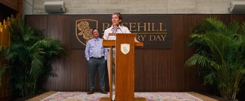 Movie still from “Do Revenge” (2022), directed by Jennifer Kaytin Robinson – A man standing at a podium speaking to a crowd; Wide shot, Low angle